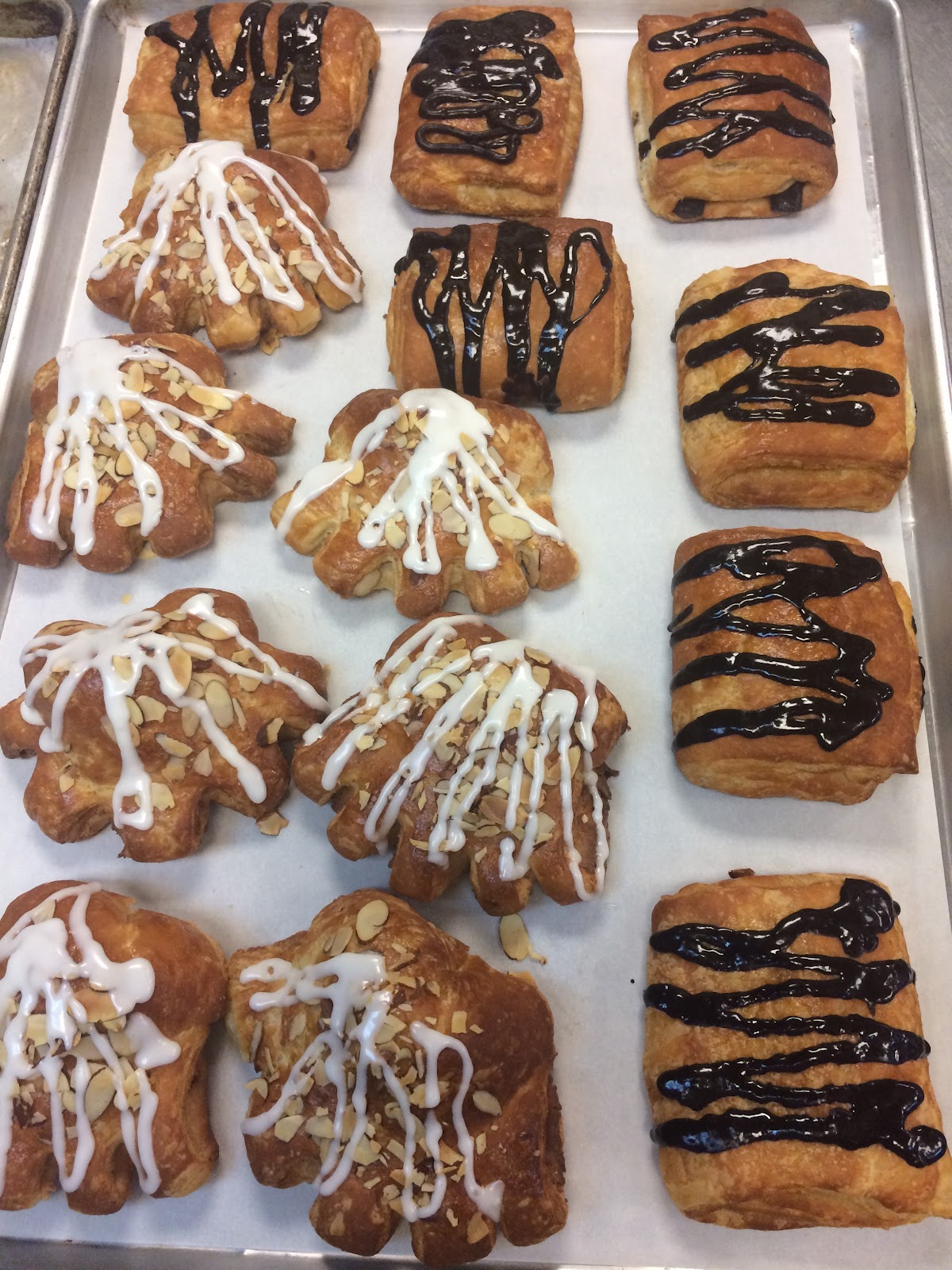 A tray of glazed almond bear-claws and chocolate danishes